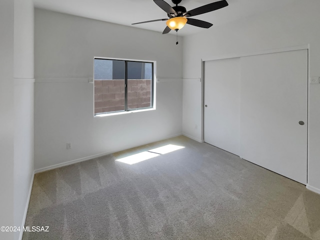 unfurnished bedroom featuring light colored carpet, ceiling fan, and a closet