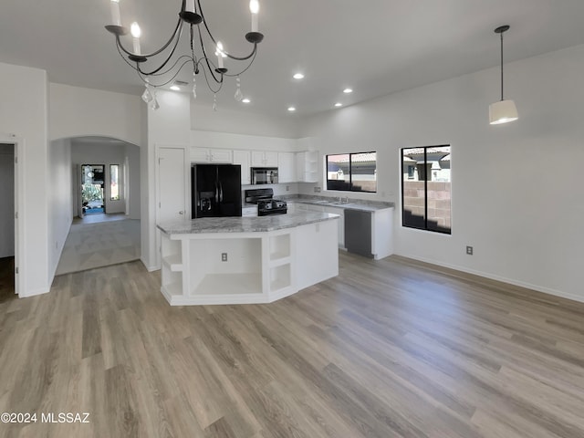 kitchen featuring white cabinets, a kitchen island, light hardwood / wood-style floors, and black appliances