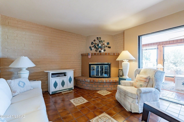 living room with dark tile patterned floors and a fireplace