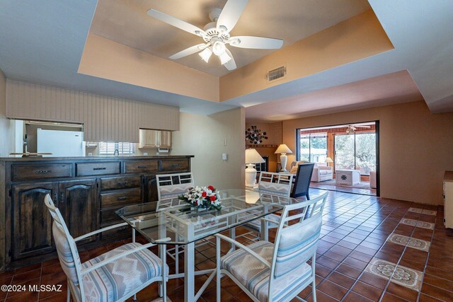 dining room featuring brick wall, a ceiling fan, visible vents, and tile patterned floors