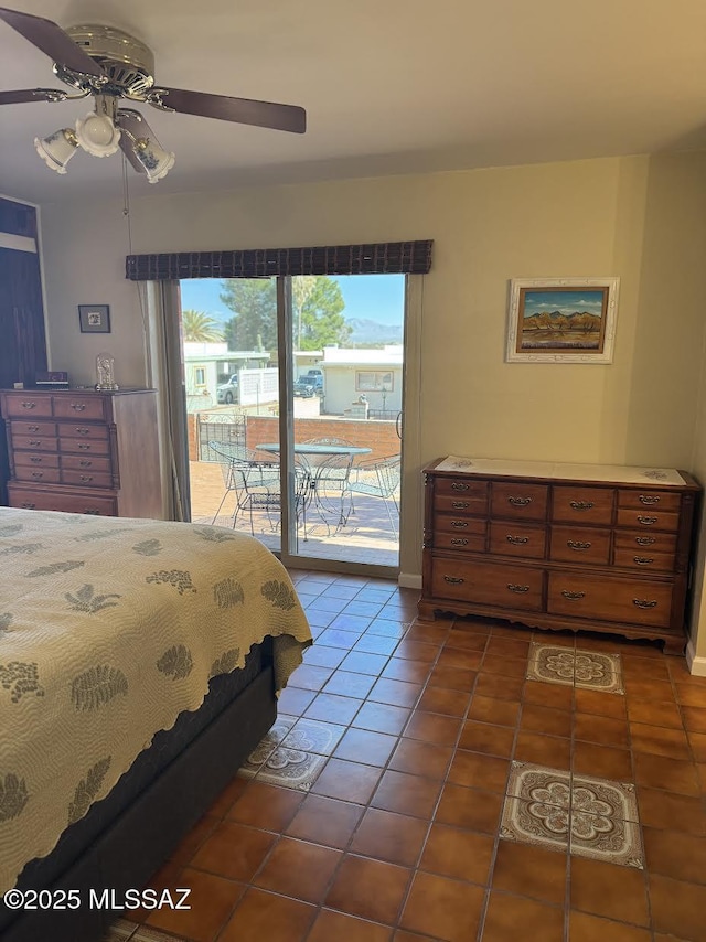 bedroom featuring access to outside, dark tile patterned flooring, and ceiling fan