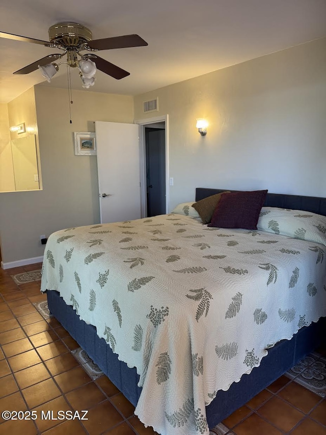 bedroom with ceiling fan, tile patterned flooring, visible vents, and baseboards