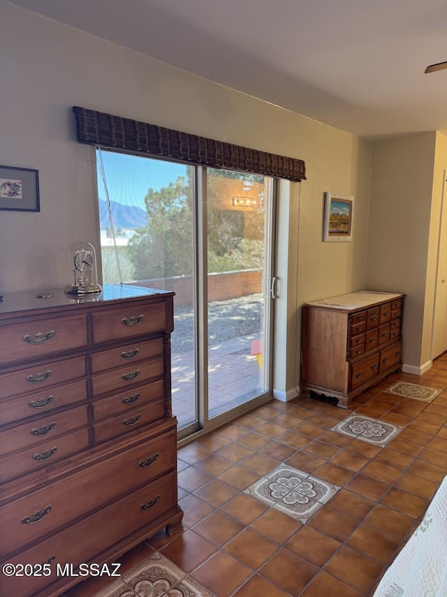 bedroom with baseboards, tile patterned floors, and access to exterior