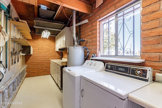 washroom featuring brick wall, water heater, log walls, cabinet space, and washer and clothes dryer