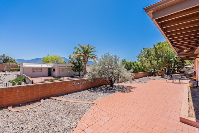 view of patio / terrace featuring fence private yard and a mountain view