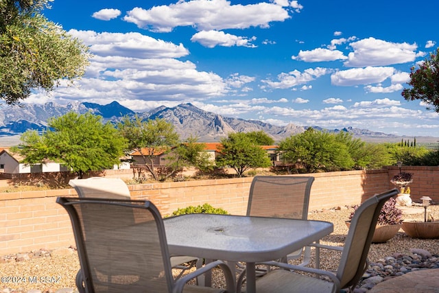 view of patio / terrace featuring outdoor dining space, fence private yard, and a mountain view