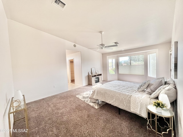 carpeted bedroom with vaulted ceiling, visible vents, and a ceiling fan