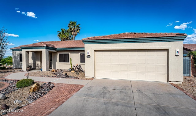 view of front of property featuring a garage, concrete driveway, a tile roof, and stucco siding