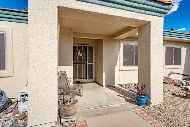 doorway to property with a patio area and stucco siding