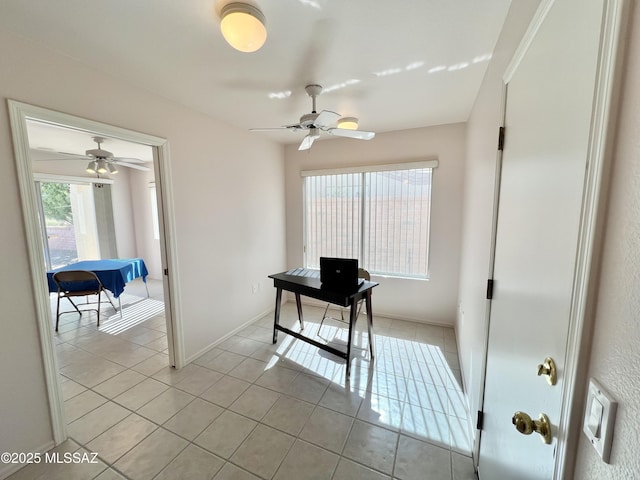 office featuring baseboards, a ceiling fan, and light tile patterned flooring