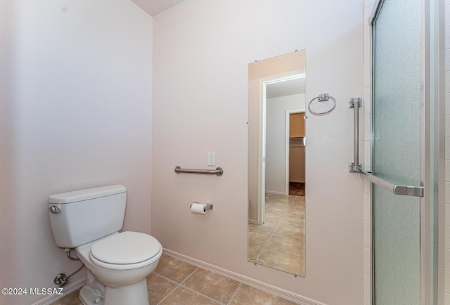 full bathroom featuring baseboards, a shower with shower door, toilet, and tile patterned floors