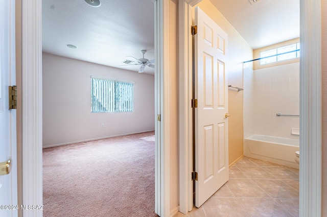 full bath with tile patterned flooring, ceiling fan, baseboards, and shower / bathtub combination