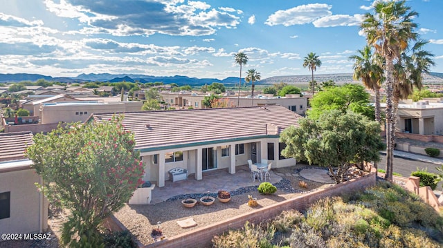 exterior space featuring a patio, a tile roof, a mountain view, and stucco siding