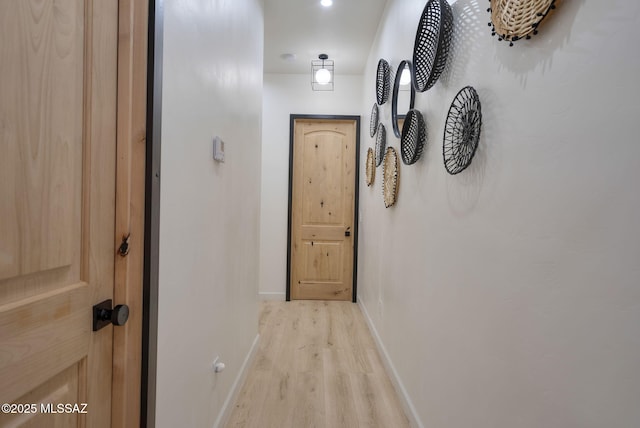 hall featuring baseboards and light wood-style floors