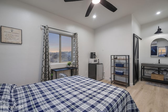 bedroom with light wood-type flooring, ceiling fan, baseboards, and recessed lighting