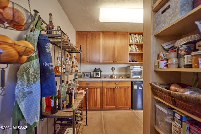 kitchen featuring brown cabinetry, open shelves, and light tile patterned floors