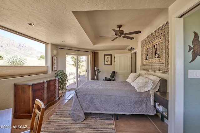 bedroom with a mountain view, a textured ceiling, access to outside, and visible vents