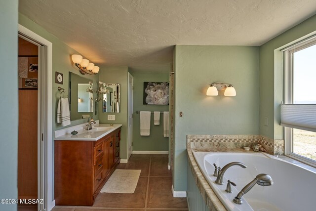 full bathroom with a textured ceiling, a bath, a healthy amount of sunlight, and tile patterned floors