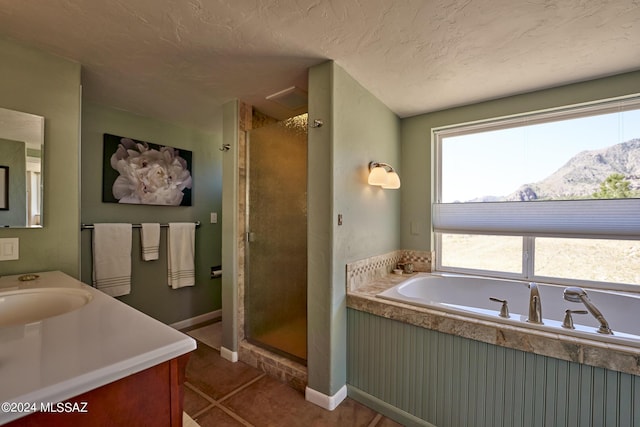 bathroom with a mountain view, vanity, tile patterned flooring, a shower stall, and a bath