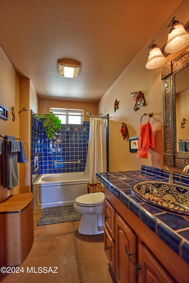 full bathroom featuring shower / bath combo with shower curtain, vanity, a textured ceiling, and toilet