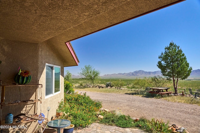 view of yard with a rural view and a mountain view