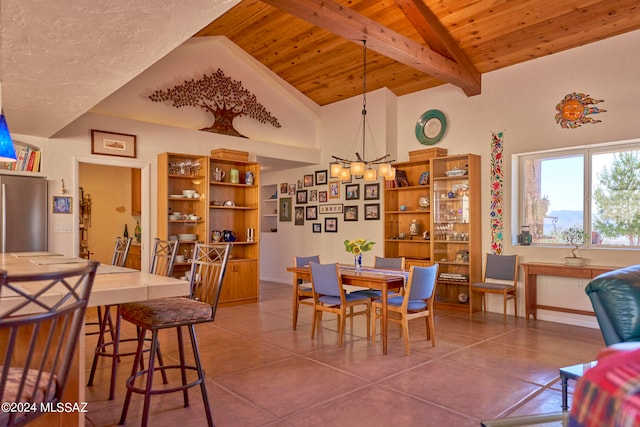 dining area with tile patterned floors, vaulted ceiling with beams, wooden ceiling, and an inviting chandelier