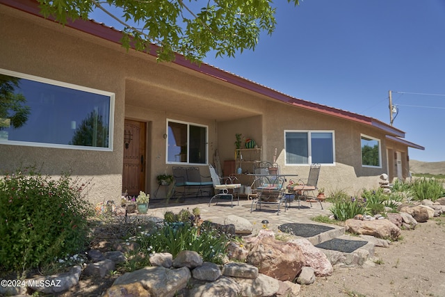 back of house with a patio area and stucco siding