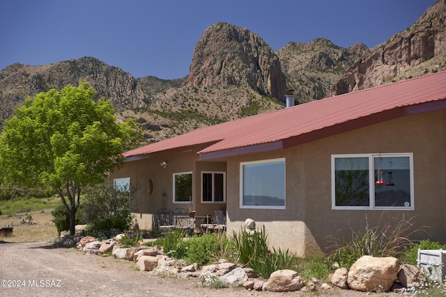 exterior space with metal roof, stucco siding, and a mountain view