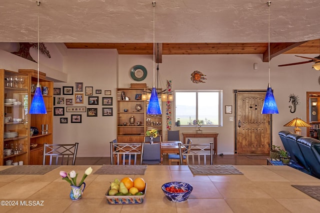 dining space featuring ceiling fan, baseboards, and beamed ceiling