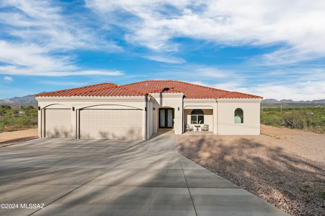 mediterranean / spanish-style house with a mountain view and a garage