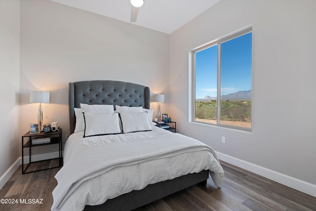 bedroom featuring baseboards, wood finished floors, and a ceiling fan