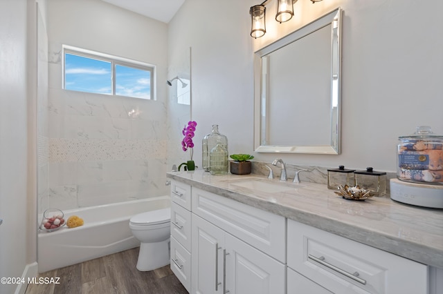 full bath featuring toilet, wood finished floors, vanity, and shower / bathtub combination