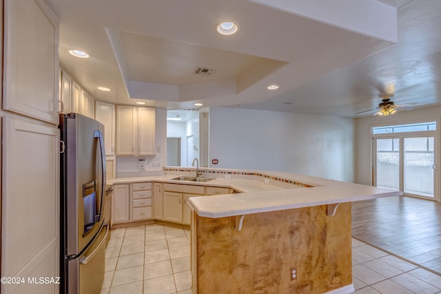 kitchen with stainless steel fridge with ice dispenser, light hardwood / wood-style flooring, ceiling fan, a breakfast bar area, and sink