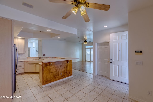 kitchen featuring sink, ceiling fan, and light tile flooring