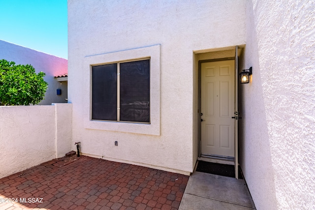 view of exterior entry with a patio area