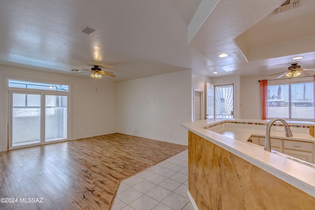 kitchen with sink, light tile flooring, and ceiling fan