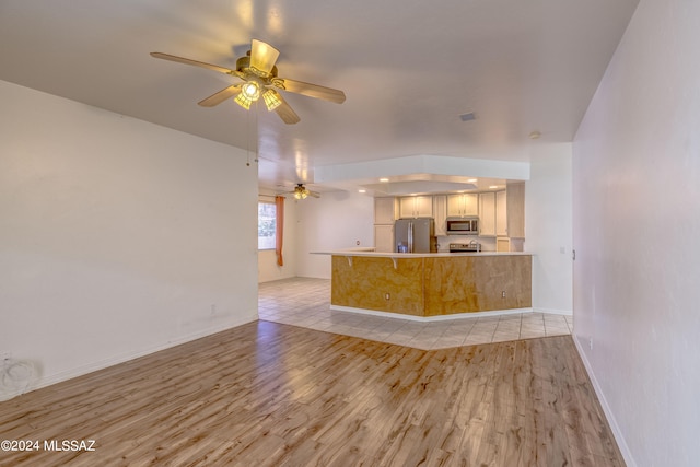 unfurnished living room with ceiling fan and light wood-type flooring