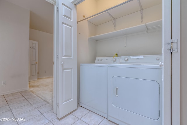 clothes washing area featuring washer and dryer and light tile floors