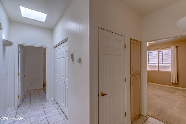 hallway featuring light carpet and a skylight