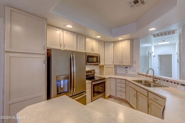 kitchen featuring white cabinets, appliances with stainless steel finishes, sink, and light tile floors