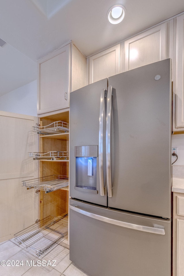 kitchen featuring white cabinets, stainless steel refrigerator with ice dispenser, and light tile floors