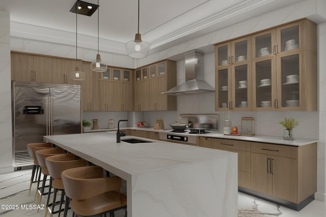 kitchen featuring sink, a breakfast bar area, hanging light fixtures, stainless steel appliances, and wall chimney range hood