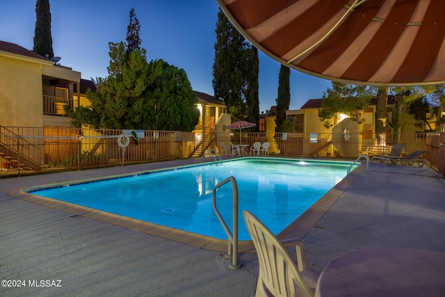 pool at dusk with a patio