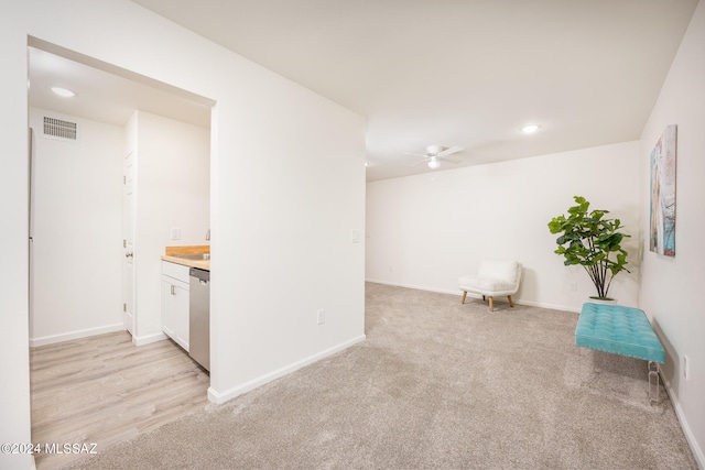 interior space featuring light carpet and ceiling fan