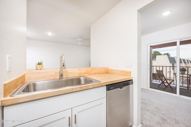 kitchen with white cabinets, dishwasher, carpet flooring, and sink