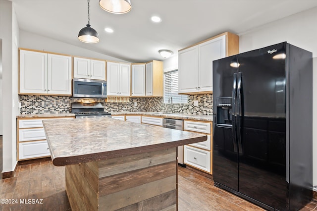 kitchen featuring decorative light fixtures, a kitchen island, backsplash, and stainless steel appliances