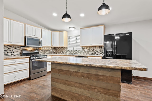 kitchen with backsplash, pendant lighting, stainless steel appliances, and a kitchen island