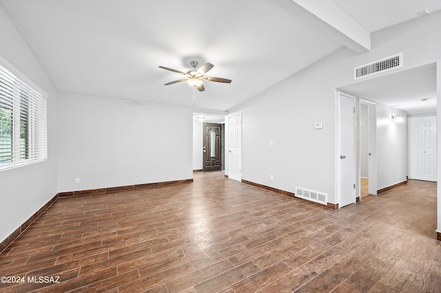 spare room featuring dark hardwood / wood-style flooring, ceiling fan, and vaulted ceiling with beams