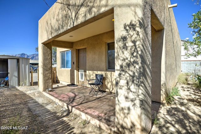 rear view of property with an outdoor structure and a patio area