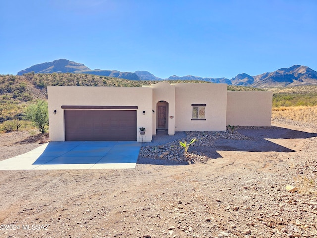 pueblo revival-style home featuring a mountain view and a garage